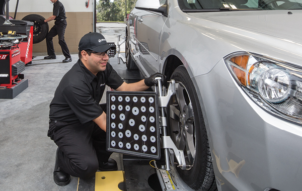 Technician aligning tires on a car