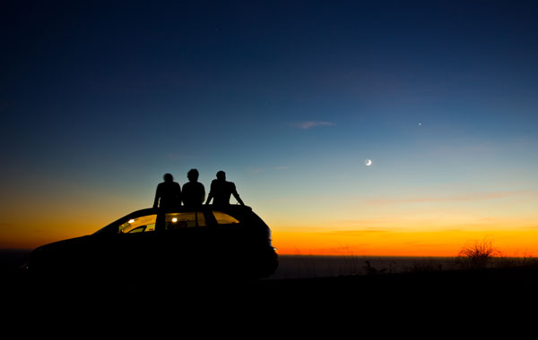 Family on car looking at night sky